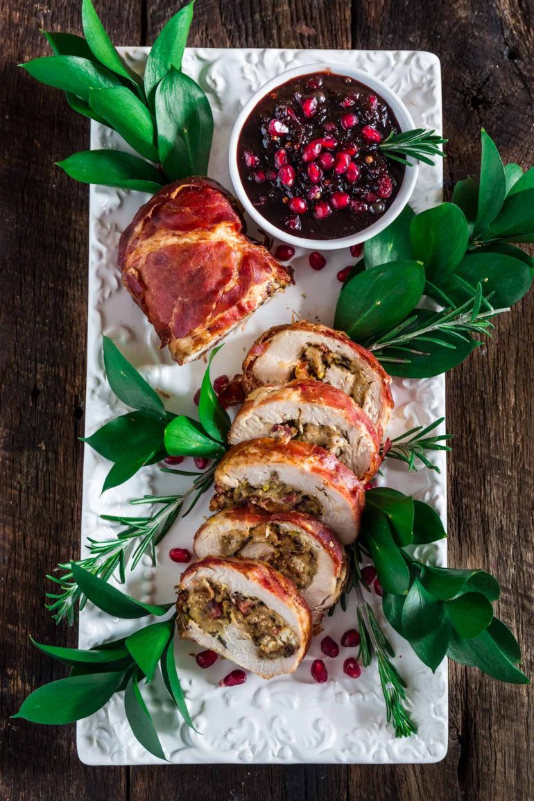 Slices of prosciutto-wrapped turkey stuffed with dressing, served with a pomegranate reduction on the side